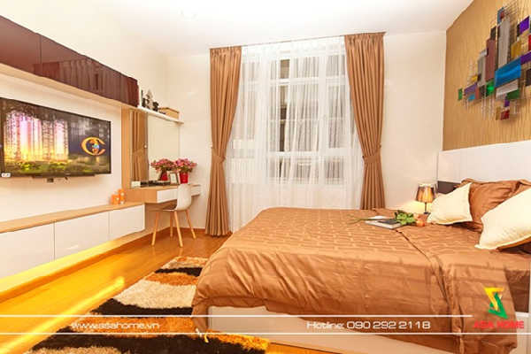Phòng ngủ nổi bật với sàn nhà màu gỗ đậm dưới ánh đèn vàng cũng những vật dụng trang trí đầy màu sắc